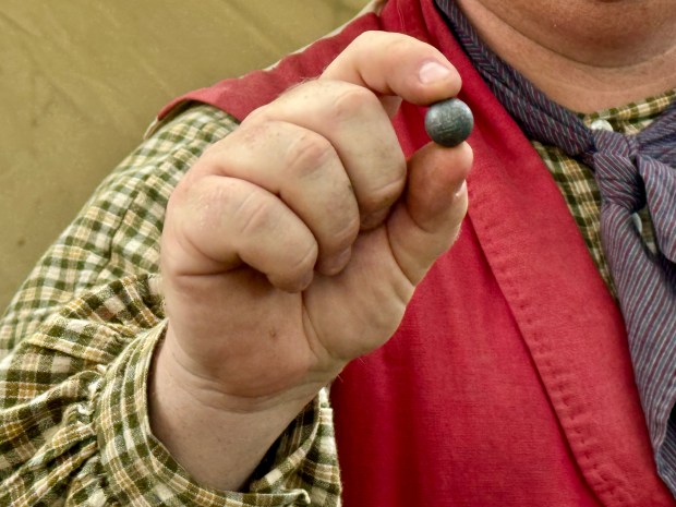 Ian Baker, of Michigan City, shows a round ball used as ammunition in guns during the Revolutionary War era. (Doug Ross/Post-Tribune)