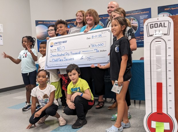 Children joined NEO officials JuliAnn Nisevich, center left, Rebecca Reiner, center, and Adam O'Doherty, president and CEO of United Way Northwest Indiana, which presented a $750,000 check Sunday to establish Creekside Early Learning Center at NEO in Portage. (Carole Carlson/Post-Tribune)