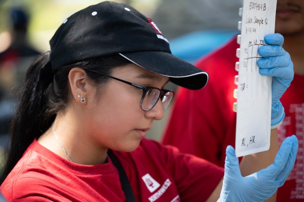 Incoming biology student Aurora Lujen, of Griffith, checks a sample of water from Lake Michigan that will be used to measure E. coli content during Indiana University Northwest's Summer Bridge program for incoming students on Tuesday, Aug. 13, 2024. (Kyle Telechan/for the Post-Tribune)