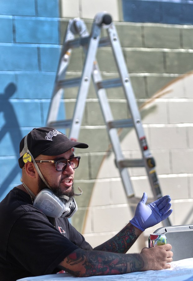 Artist Gabriel Barajas describes his idea behind the work he is doing during during Mural Week put on by the Valparaiso Creative Council as artists created murals as part of a goal of making downtown Valpo an arts mecca on Saturday, Aug. 24, 2024. (John Smierciak/for the Post-Tribune)