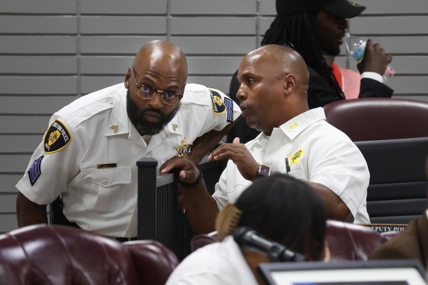 Dolton Deputy Police Chief Lewis Lacey, right, talks to a sergeant Aug. 5, 2024, before the start of a Dolton Village Board meeting. (Terrence Antonio James/Chicago Tribune)