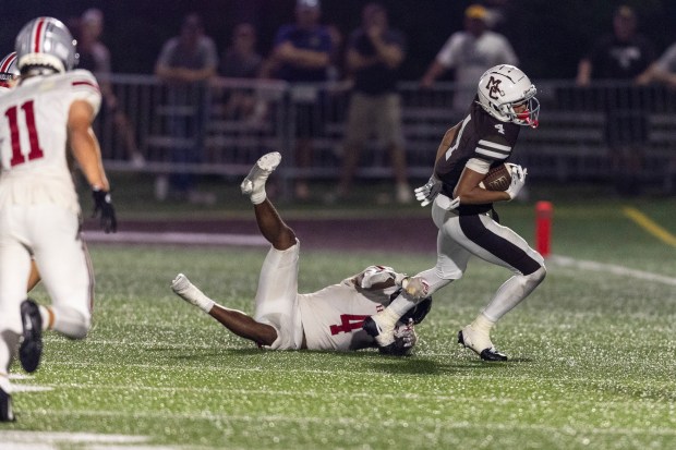 Mount Carmel's Quentin Burrell (4), tries to slip away from Chase Enlow of the Hun School of Princeton from New Jersey during a nonconference game in Chicago, on Thursday, Aug. 29, 2024. (Vincent D. Johnson/for the Daily Southtown)