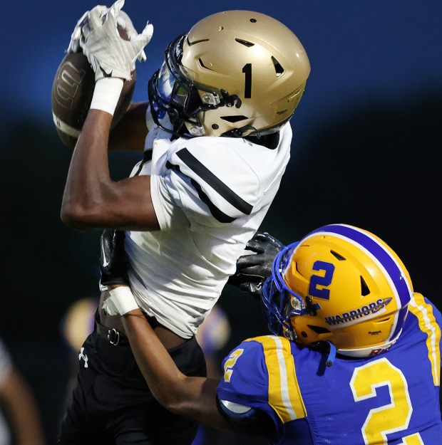 Richard's Milan Mosley (1) pulls in a long pass over Crete-Monee's Kaliq Wood (21) in the first half during a football game in Crete on Friday, Aug. 30, 2024. (John Smierciak/ Daily Southtown)