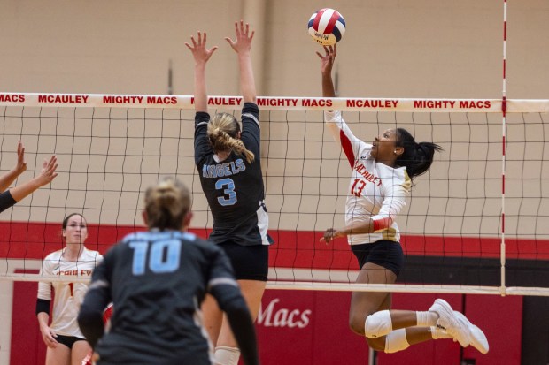 Mother McAuley's Sydney Buchanan (13) tips the ball over Joliet Catholic's Brooke Simon (3) during a nonconfernce game in Chicago, on Tuesday, Aug.. 27, 2024. (Vincent D. Johnson/for the Daily Southtown)