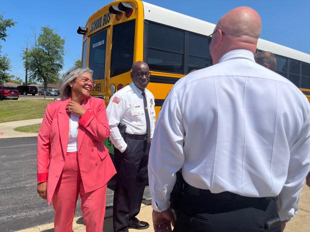 Illinois U.S. Rep. Robin Kelly speaks with Calumet City police Aug. 7, 2024, in front of an electric school bus. (Olivia Stevens/Daily Southtown)