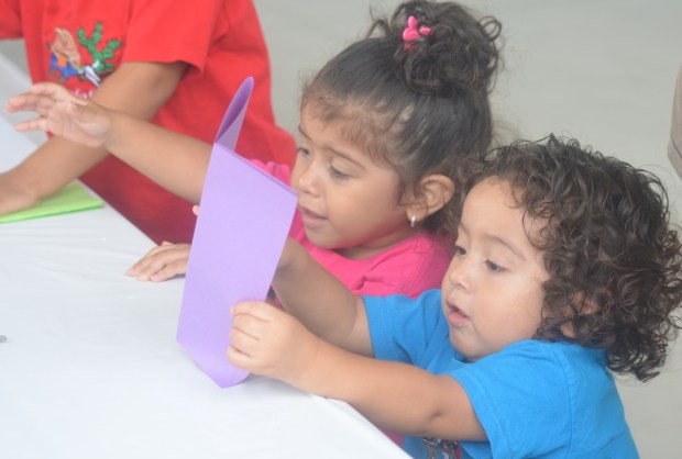 One-year-old twins Violet, left, and Cristiano Palacios, of Calumet City, start to work on a project Aug. 17, 2024, at Cultural Celebration Day in Lansing. (Jeff Vorva/for the Daily Southtown)