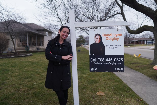 Manhattan real estate agent Randi Quigley stands next to a sign for eXp Realty, the real estate brokerage firm she works for. (Courtesy of Randi Quigley)