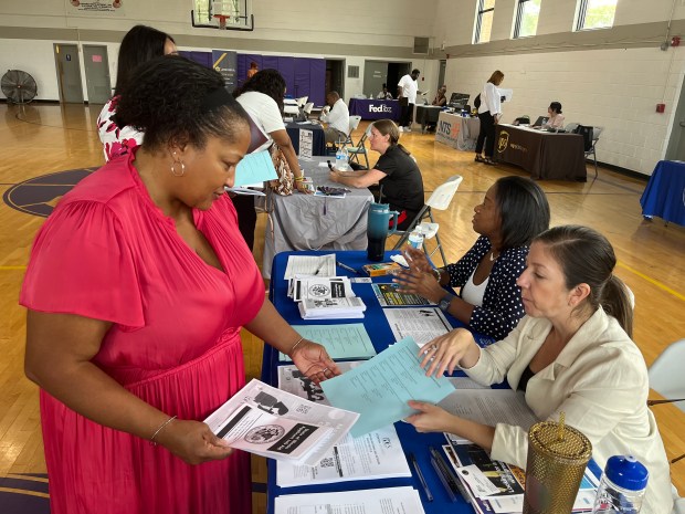 Lawanda Gosa, community outreach director for Robbins, collects informational packets Aug. 27, 2024, at the Illinois Department of Employment Security table at a job fair she organized in Robbins. (Samantha Moilanen/Daily Southtown)