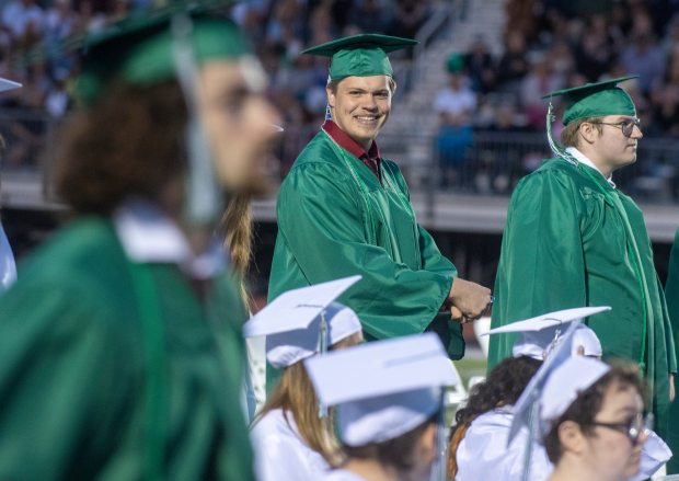 Mitchell Tomczak smiles while watching fellow seniors line up to get their diplomas during commencement ceremonies at Valparaiso High School in Valparaiso, Indiana Wednesday June 1, 2022. Tomczak graduated as a member of the Porter County Career Center Technical Honor Society. (Andy Lavalley for the Post-Tribune)