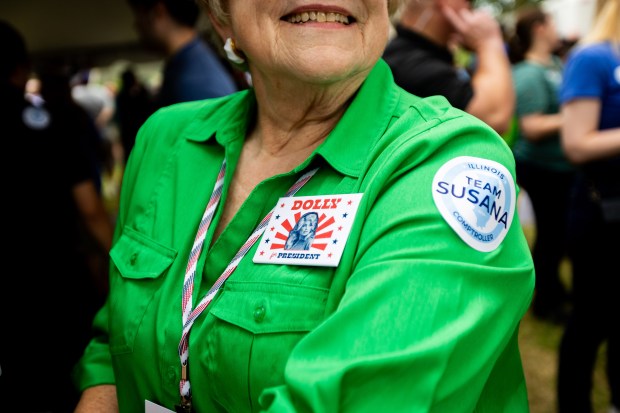 Jo Webster, of West Point, Illinois, shows her Dolly Parton pin at Governor's Day at the Illinois State Fair in Springfield on Aug. 14, 2024. Webster came with the Hancock County Democrats. "I just got back from Dollywood. Hancock County is red so I feel safe wearing a Dolly pin. We have to defeat Trump with a woman candidate. I sat in front of the TV and sobbed the first time he won. I have been upset about it ever since," she said. (Tess Crowley/Chicago Tribune)