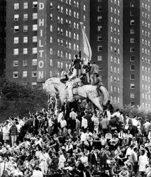 Demonstrators climb the statue of General Logan in Grant Park, across from the Conrad Hilton, while thousands gather on the ground during the Democratic National Convention on Aug. 29, 1968. Many of the convention delegates were staying at the Hilton. (James Mayo/Chicago Tribune)