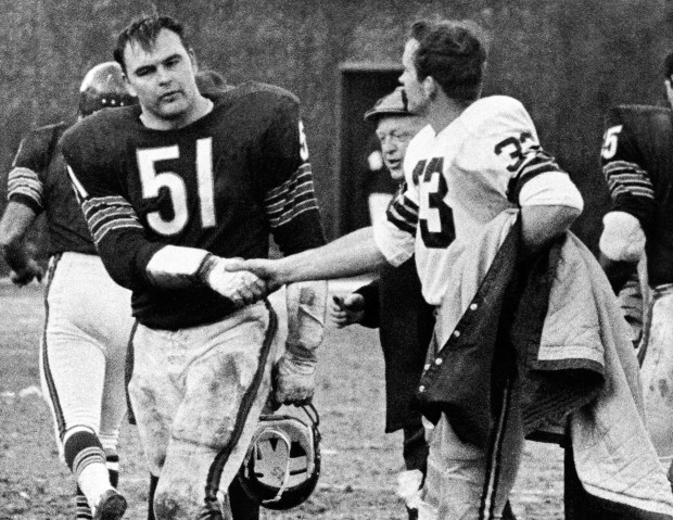 Bears linebacker Dick Butkus, left, shakes hands with Packers running back Jim Grabowski on Nov. 27, 1967, after their game in Chicago. Butkus and Grabowski were teammates at Illinois. (Charles Harrity/AP)