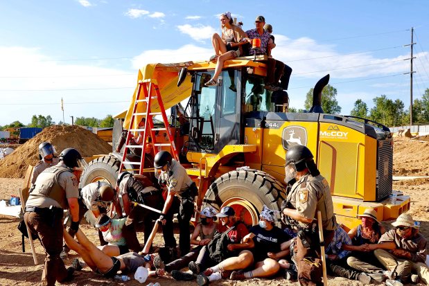 Police in riot gear arrest environmental activists at the Line 3 pipeline pumping station near the Itasca State Park in Minnesota on June 7, 2021. Line 3 is an oil sands pipeline which runs from Hardisty, Alberta, Canada to Superior, Wisconsin in the United States. While many people are concerned about potential oil spills along Line 3, some Native American communities in Minnesota have opposed the project on the basis of treaty rights and calling President Biden to revoke the permits and halt construction. (Kerem Yucel/Getty-AFP)