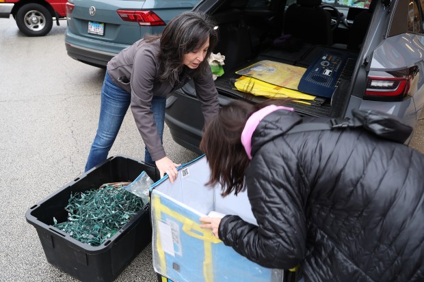 Sherry Skalko, left, founder of Reduce Waste Chicago, a nonprofit that works to address climate change through waste reduction, and her friend Inka Cherry pick up Christmas tree lights at Unwaste Shop, 1108 W. Madison Street in Chicago, on Friday, Dec. 29, 2023. (Terrence Antonio James/Chicago Tribune)