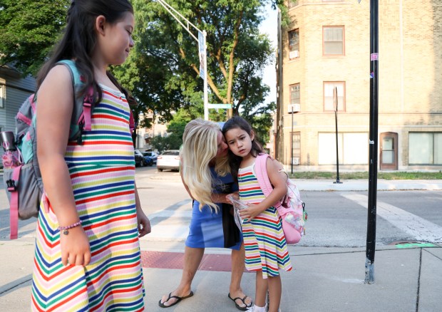 Suzanne Mak speaks to her daughters, third-grader Eisley Mak, left, and kindergartner Addie Mak on their first day of school at Hamilton Elementary School in Lake View on Monday, Aug. 26, 2024. (Eileen T. Meslar/Chicago Tribune)