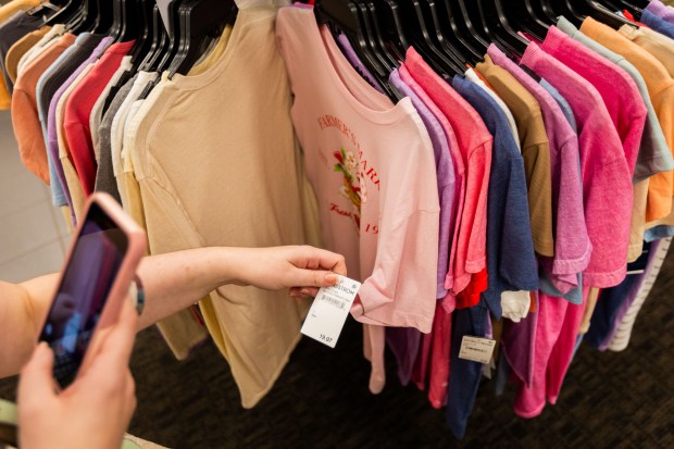 Rosie Albrecht, 26, from Chicago, examines clothes for a TikTok video at the State Street Nordstrom Rack in Chicago on Aug. 9, 2024. (Tess Crowley/Chicago Tribune)