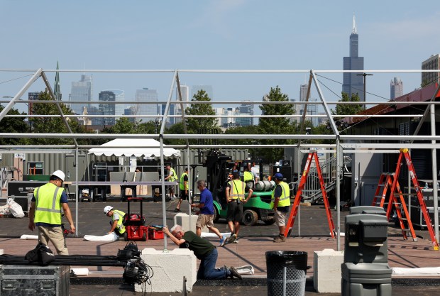 Workers construct temporary structures at a parking lot in preparation for the Democratic National Convention at the United Center on Aug. 14, 2024, in Chicago. (John J. Kim/Chicago Tribune)