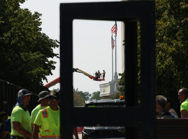 Workers stand in a basket lift during preparations for the Democratic National Convention at the United Center Wednesday, Aug. 14, 2024, in Chicago. (John J. Kim/Chicago Tribune)