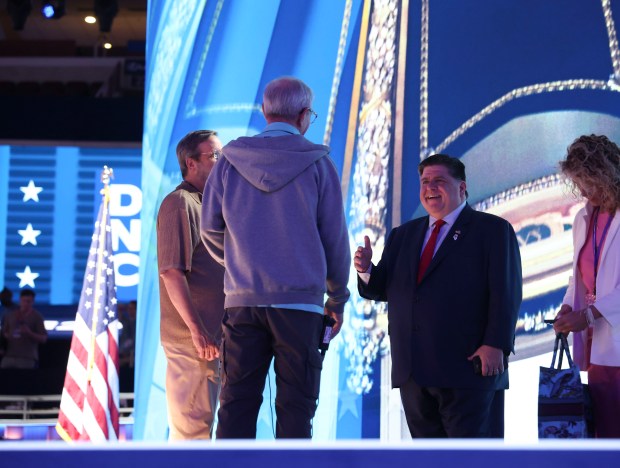 Gov. JB Pritzker greets people while visiting the stage before the Democratic National Convention Aug. 16, 2024, at the United Center. (Brian Cassella/Chicago Tribune)