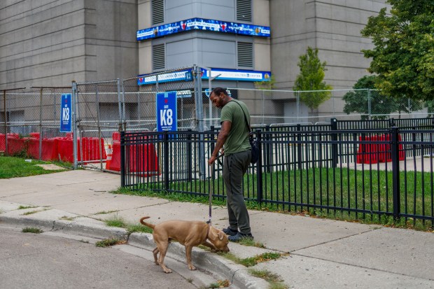 Frederick Alonzo walks his dog outside the United Center near his home at the Chicago Housing Authority's Henry Horner Annex on Tuesday, Aug. 6, 2024, in Chicago.(Armando L. Sanchez/Chicago Tribune)