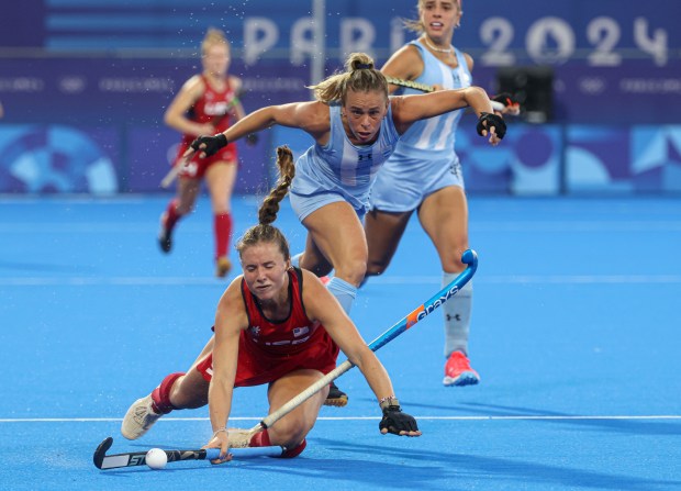 USA's Maddie Zimmer, of Northwestern, goes down against Argentina's Victoria Sauze Valdez in a field hockey pool play match Saturday, July 27, 2024, at Stade Yves-du-Manoir during the Paris Olympics. (Brian Cassella/Chicago Tribune)