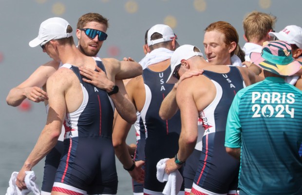 Peter Chatain, left in blue sunglasses, and his USA men's eight boat teammates celebrate winning the bronze medal in rowing Saturday, Aug. 3, 2024, at Vaines-sur-Marne Nautical Stadium during the Paris Olympics. (Brian Cassella/Chicago Tribune)