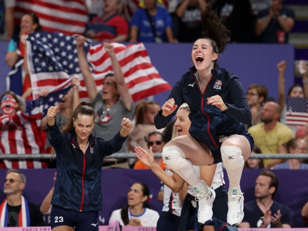 USA's Dana Rettke, right, and Kelsey Robinson Cook, left, cheer on their teammates as they defeat France 3-0 to advance to the volleyball quarterfinals, Aug. 4, 2024, at South Paris Arena 1 during the Paris Olympics. (Brian Cassella/Chicago Tribune)