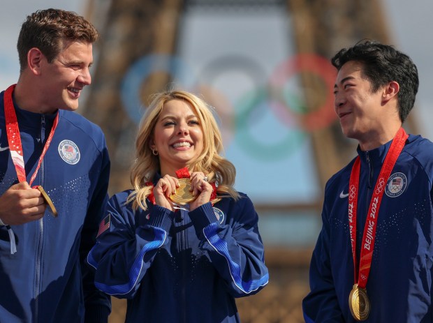 Alexa Knierim, center, with her USA figure skating teammates Brandon Frazier and Nathan Chen finally receive their gold medals from the 2022 Beijing Winter Olympics on Aug. 7, 2024, in front of the Eiffel Tower at Champions Park in the Trocadero during the Paris Olympics. The presentation was delayed more than two years after a Russian skater tested positive for a banned substance. (Brian Cassella/Chicago Tribune)