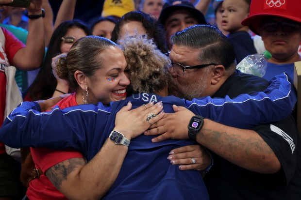 USA's Kennedy Blades hugs her parents, Cindy Ramos and Saul Pulido, after taking the silver medal, falling to Japan's Yuka Kagami 3-1 in the final match of the women's 76kg freestyle wrestling Sunday, Aug. 11, 2024, at Champ de Mars Arena during the Paris Olympics. (Brian Cassella/Chicago Tribune)