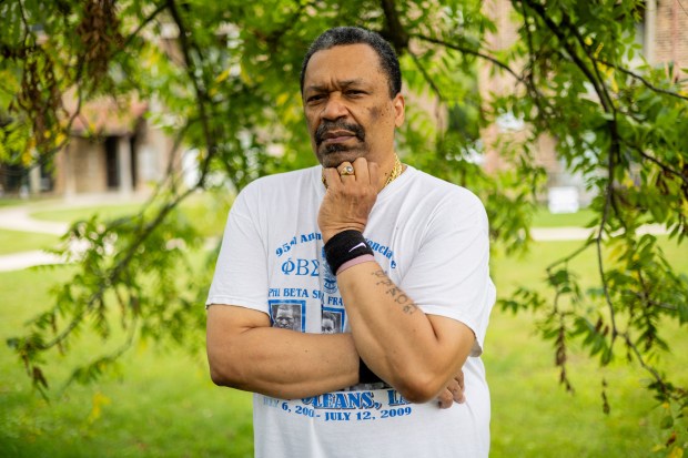 Marc Atkins, 66, with his class ring and Phi Beta Sigma Fraternity shirt from DeVry University outside his home in Homewood on July 24, 2024. (Tess Crowley/Chicago Tribune)