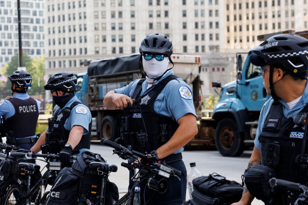 Officers stand by their bikes while activists gather near North Michigan Avenue to protest the Democratic National Convention on Aug. 18, 2024, in Chicago. (Armando L. Sanchez/Chicago Tribune)