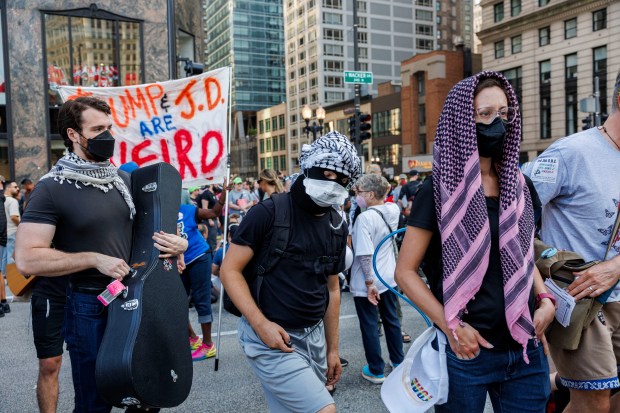 Activists gather near North Michigan Avenue to protest the Democratic National Convention on Aug. 18, 2024, in Chicago. The protest was organized by CODEPINK, a women-led anti-war nonprofit that seeks to redirect tax dollars into healthcare, education and green jobs. (Armando L. Sanchez/Chicago Tribune)