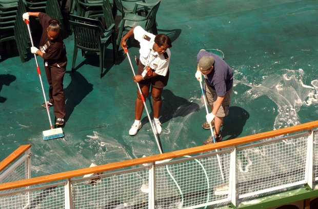 The crew of Chicago's Little Lady tour boat, Crystal Brown, from left, Audrey Rudd and Brian Burke, clean up the mess that was apparently dumped on them from a passing tour bus lavatory off of the Kinzie Street Bridge on Aug. 8, 2004. The Little Lady was giving an architectural tour along the river at the time of the incident. (Chuck Berman/Chicago Tribune)