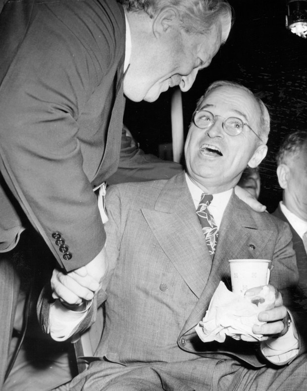 Senator Harry S. Truman, of Missouri, whose vice-presidential nomination ambitions reached a red-hot impetus, puts aside a hotdog and container of coffee to greet Sen. Pat McCarran, of Nevada, on the Democratic National Convention floor in Chicago on July 21, 1944. (Associated Press)