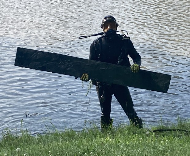 A diver finds a board at the bottom of the Brevier Park pond. (Steve Sadin/For the Lake County News-Sun)