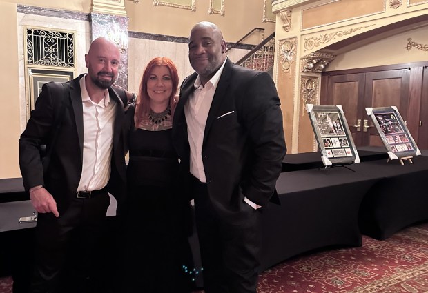 From left, HOTC sporting director Dean Smith, executive director Rena Lee and past executive director Scott McLellan, pose next to some of the sports memorabilia on auction at the Soccer for Success gala in Waukegan on Aug. 10. (Yadira Sanchez Olson/For the Lake County News-Sun)