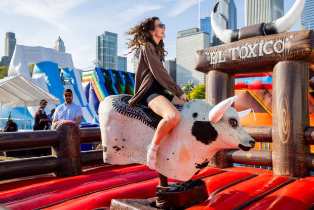 Libby Ebeling rides a bull at El Grito Chicago, a two-day festival in celebration of Mexican Independence Day, at Grant Park's Butler Field in Chicago on Sept. 14, 2024. (Tess Crowley/Chicago Tribune)