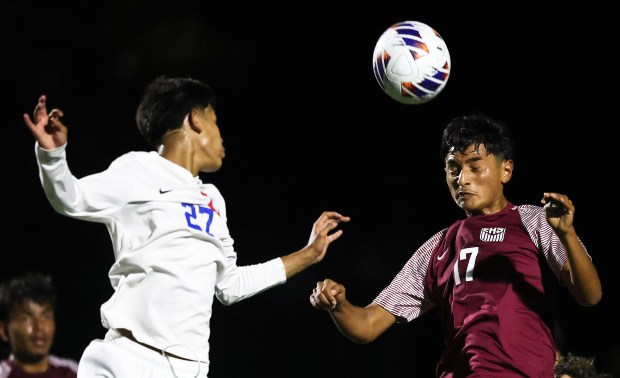 Elgin's Xavier Salinas (17) heads the ball past Larkin defender Alan Chavez (27) during an Upstate Eight Conference crosstown match on Thursday, Sept. 12 in Elgin. (H. Rick Bamman / The Beacon News)