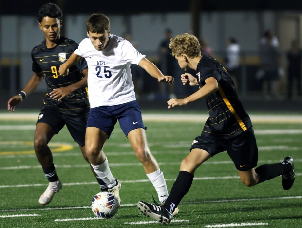 West Aurora's Mason Aguirre (25) moves the ball as Elmwood Park's Christian Arango (9) and Andriy Gasyuk (22) defend during a boys soccer game in Elmwood Park on Tuesday, Sept. 3, 2024. (James C. Svehla / Pioneer Press)