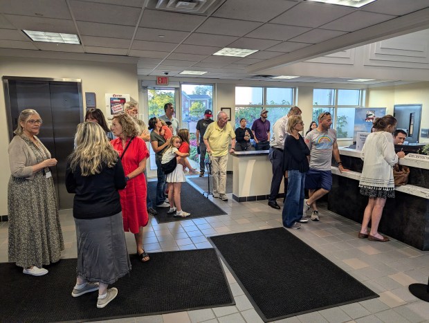 People congregate in the lobby of St. Charles City Hall to watch Wednesday's Plan Commission meeting on TVs because the Council Chambers and two overflow rooms were already full. (R. Christian Smith / The Beacon-News)