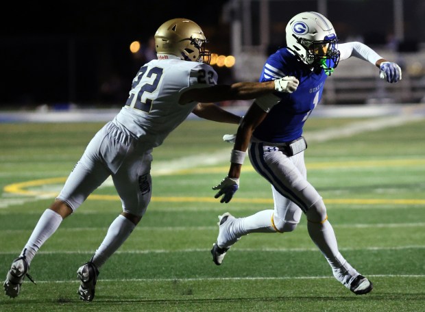 Geneva's Talyn Taylor, right, runs the play as Lemont's Jakub Maka defends during the football game in Geneva on Friday, Sept. 6, 2024. (James C. Svehla / Beacon News)