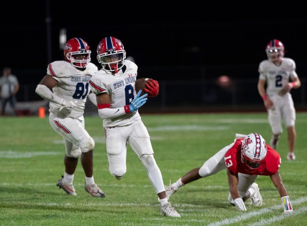 West Aurora's Bryce Riley, 8, escapes a tackle from South Elgin's D'Andre Bartee II during an Upstate Eight Conference game in South Elgin on Friday, Sept. 20, 2024. (Ryan Rayburn / for The Beacon News)