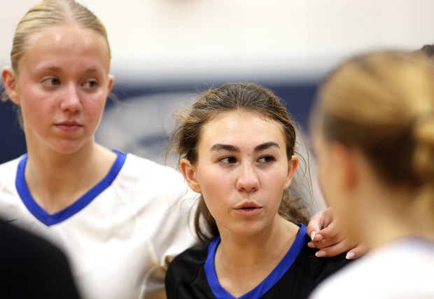 Burlington Central's Leah Freesemann, left, listens as Brianna Gritzman talks in the huddle after a Fox Valley conference game against Cary-Grove Thursday, Sept. 26, 2024 in Cary.H. Rick Bamman / The Beacon-News