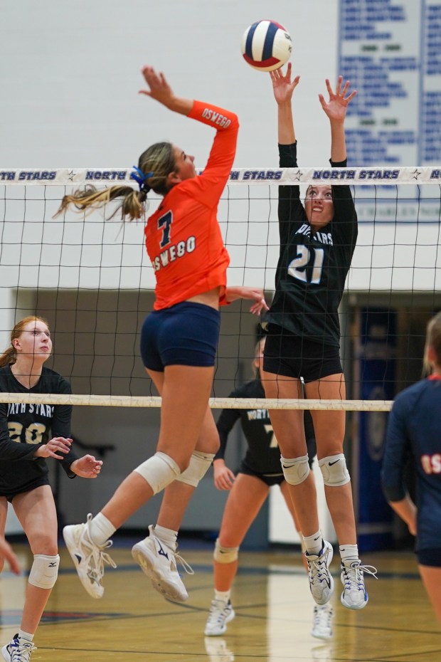 St. Charles North's Brynn Hopkins (21) defends the net against a kill attempt by Oswego's Hannah Herrick (7) during a volleyball match on Wednesday, Sep 18, 2024. in St. Charles. (Sean King / for The Beacon-News)