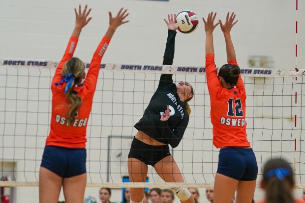 St. Charles North's Amber Czerniak (3) goes up for a kill attempt against Oswego's Hannah Herrick (7) and Ava Flanigan (12) during a volleyball match on Wednesday, Sep 18, 2024. in St. Charles. (Sean King / for The Beacon-News)