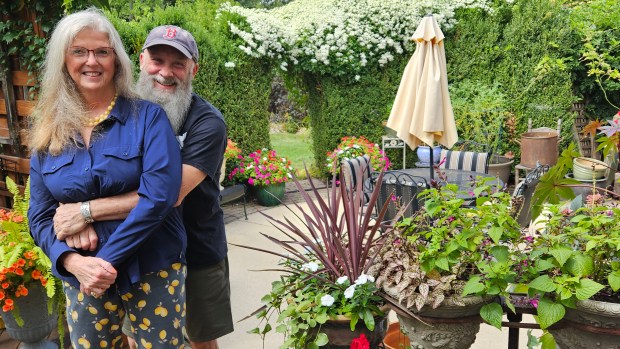 Ed and Kathryn Manning stand in one of themed gardens in the back yard of their Geneva home. (David Sharos / For The Beacon-News)