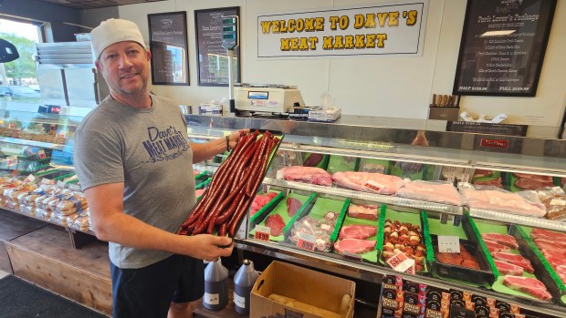 Dave Wellehan, owner of Dave's Meat Market in Yorkville, which has been open for 25 years this month, shows off some of the beef sticks that make up about 30% of his business. (David Sharos / For The Beacon-News)