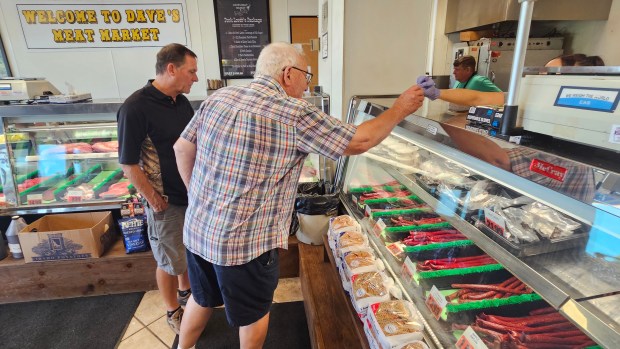 Customers enjoy samples of the beef sticks made five days a week at Dave's Meat Market in Yorkville, which has been open 25 years this month. (David Sharos / For The Beacon-News)