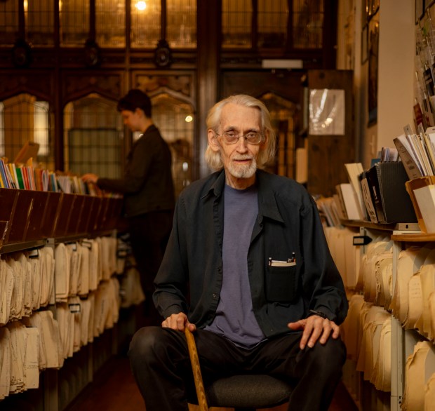 Lee Newcomer sits in the aisles of his store, Performers Music, which sells sheet music on the ninth floor of the Fine Arts Building in Chicago on Sept. 13, 2023. (Brian Cassella/Chicago Tribune)