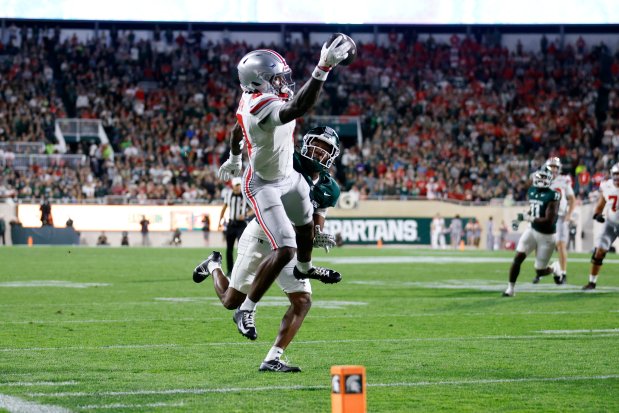 Ohio State wide receiver Jeremiah Smith makes a one-handed catch for a touchdown against Michigan State defensive back Ed Woods during the first half on Sept. 28, 2024, in East Lansing, Mich. (AP Photo/Al Goldis)